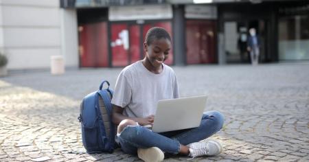 A student studying in a courtyard on a laptop using remote access software.