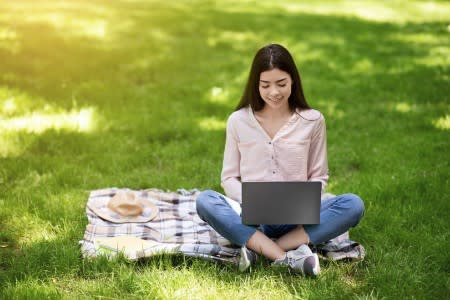 User outdoors reading Splashtop's State of Education eBook on laptop