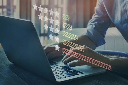 Person typing on a computer with star ratings imagery