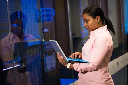 IT professional managing servers with a tablet, ensuring smooth updates with Windows Autopatch.