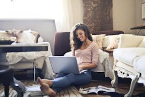 A woman smiling while using Splashtop on her laptop to work from home.