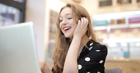 A young woman smiling while on her laptop