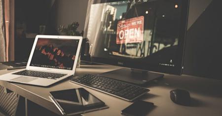 Computer and laptop placed on a wooden desk, empowered by Splashtop Remote Desktop software
