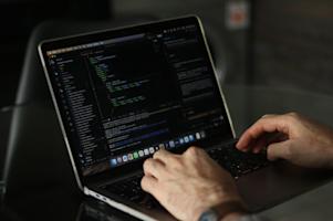 Hands typing on a laptop keyboard.