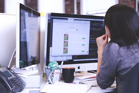 Professional woman at desk using desktop computer with Splashtop Remote Support Tools for MSPs