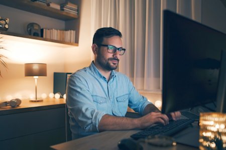 A man working on his computer at night.