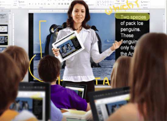 Teacher using a tablet to present to students in a classroom