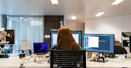 A woman at work in an office using a desktop computer.