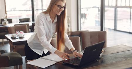 A woman working remotely in a cafe using her laptop.