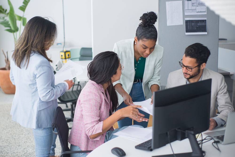 An IT team working around a computer.