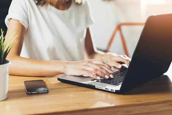 A woman typing on a laptop