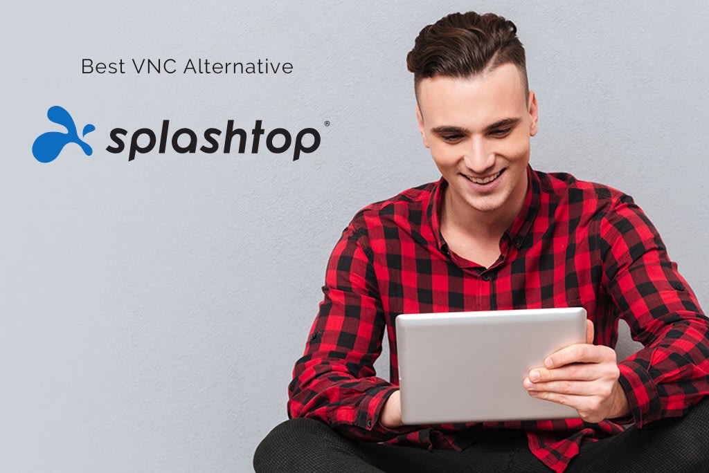 A smiling man in a red plaid shirt sits against a gray wall, holding a tablet. The Splashtop logo and the text Best VNC Alternative appear beside him.
