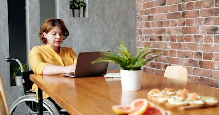 A woman in a wheelchair using her laptop with Splashtop to remotely access her office computer.