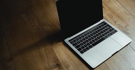 A MacBook air on a wooden floor.
