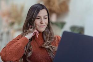 A woman smiling while usign her computer.