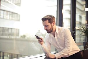 A business man using a smartphone while working.