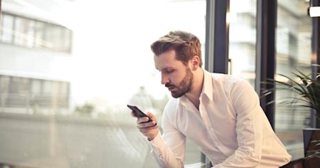 A business man using a smartphone while working.