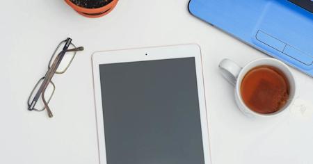 An iPad laying on a desk.
