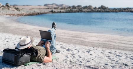Man working on a laptop at the beach, embodying remote work with Splashtop's flexible access