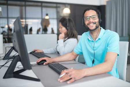 Two IT techs working at their computers.