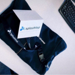 A branded Splashtop tote bag, t-shirt, and a card with the Splashtop logo are placed on a desk next to a black computer keyboard.