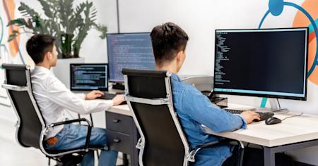 IT workers on their computers at their desks.