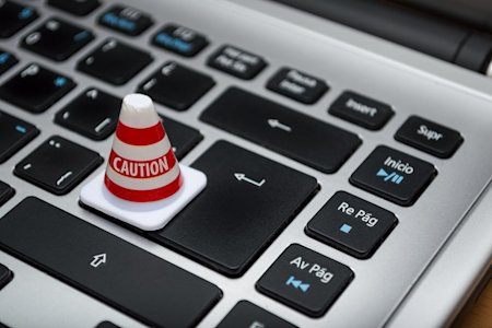 A computer keyboard with a Caution warning.