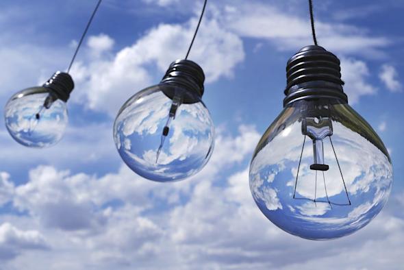 Three light bulbs hanging against a blue sky with clouds