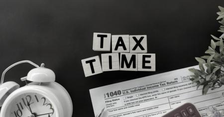 Tax time showing a clock and 1040 document in background