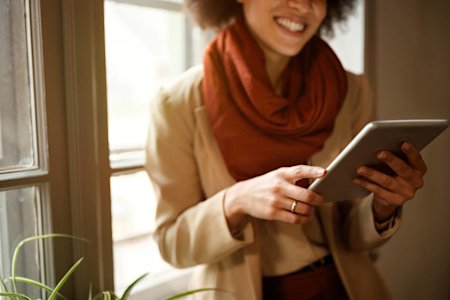A woman using Splashtop on an iPad to remotely access a desktop computer
