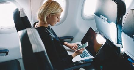 Woman sitting on a plane seat using Splashtop to remotely access a device from her laptop