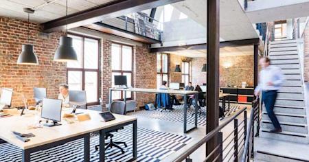 An office with several desks and computers.