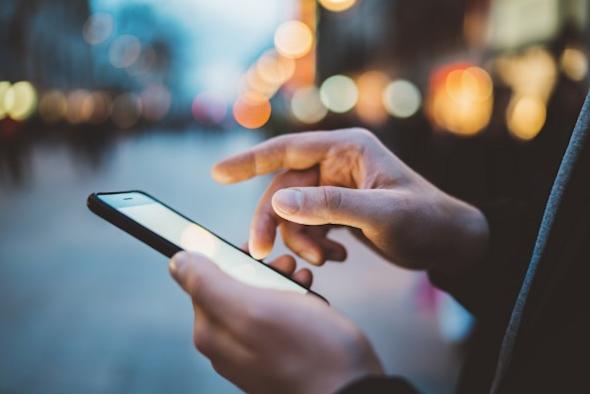 Person holding an iPhone while performing a remote session with Splashtop