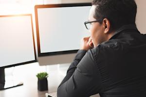 A business man using remote desktop software for dual screens.