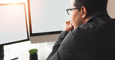 A business man using remote desktop software for dual screens.