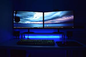 A computer with dual monitors on a desk.