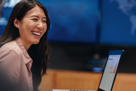A smiling woman working with Splashtop on her laptop.