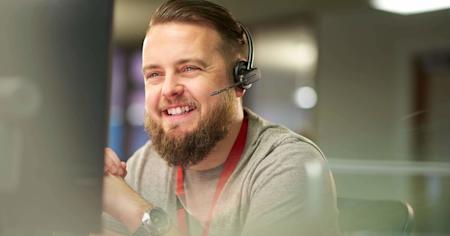 Cheerful IT technician with headset using Splashtop for remote support services