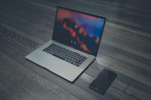 A laptop and smartphone on a desk.