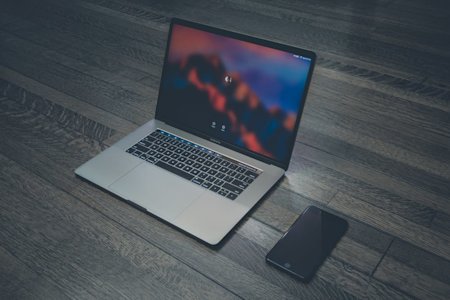 A laptop and smartphone on a desk.
