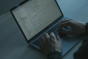 A laptop being typed on in a dark room.