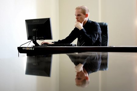 A man in an office working on a computer.