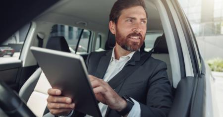 IT Specialist sitting in a car holding a tablet using Splashtop the best Remote Work Software for on the road