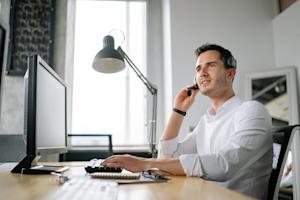 An IT service desk technician at their computer providing remote support to an end-user by using Splashtop