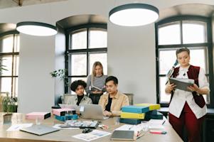 People working in a small business office with their laptops.