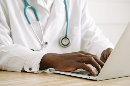 A doctor typing on a computer.