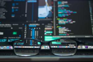 Glasses lying in front of a computer screen.