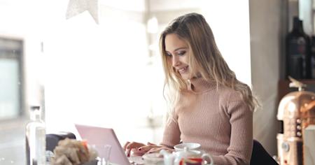 A woman smiling while using Splashtop on her laptop to work remotely.