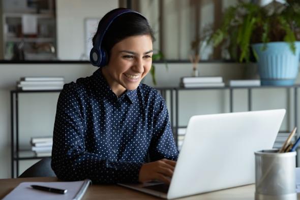 A happy IT technician using Splashtop on a laptop instead of LogMeIn