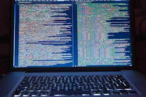 A laptop computer displaying multiple lines of code.